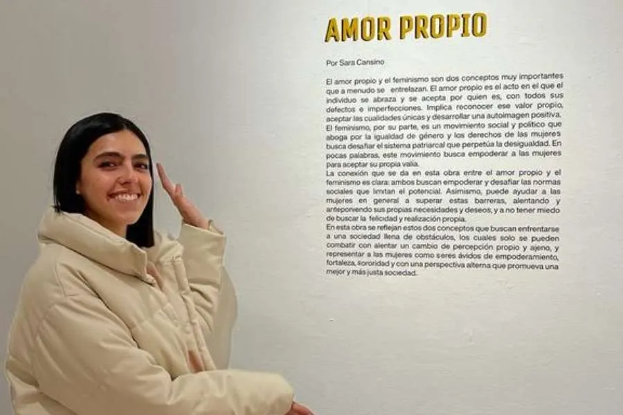 Sara Cansino posando al lado de la explicaci&oacute;n del concepto de su exposici&oacute;n
