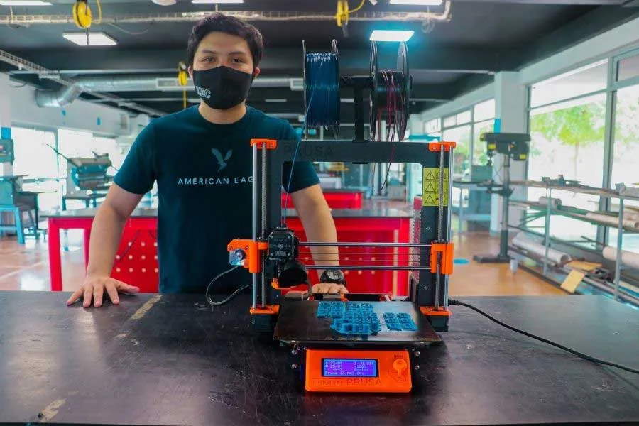 Fabio junto a la base de su emprendimiento la impresora 3D.jpg