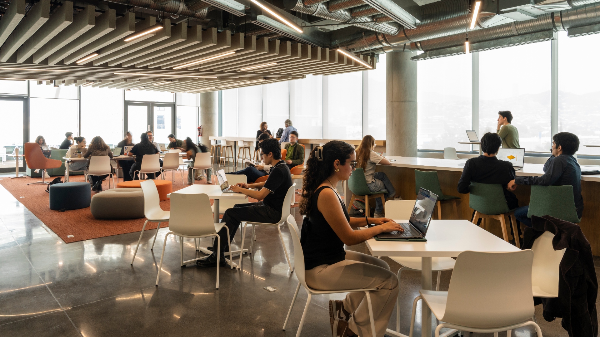 un grupo de estudiantes trabajan en conjunto en uno de los salones del hub de innovacion