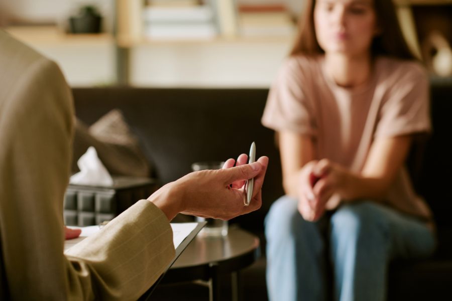 Persona en consulta psicol&oacute;gica conversando con un especialista, en un entorno interior.