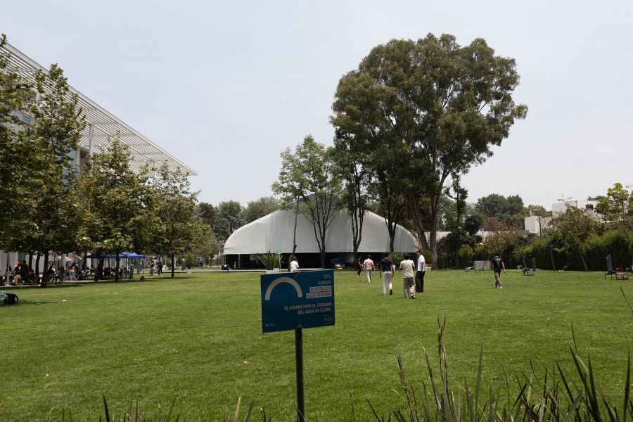 &Aacute;rea verde dentro de un campus del Tecnol&oacute;gico de Monterrey, con &aacute;rboles, jardines y estudiantes caminando alrededor de espacios abiertos.