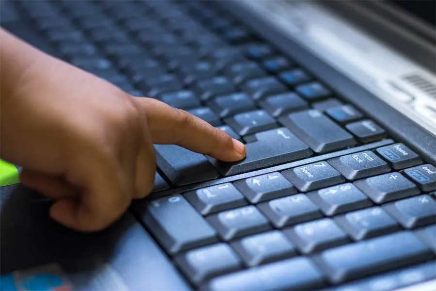 Ni&ntilde;o presionando bot&oacute;n de teclado de computadora