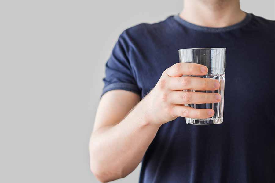 Persona sosteniendo un vaso de agua