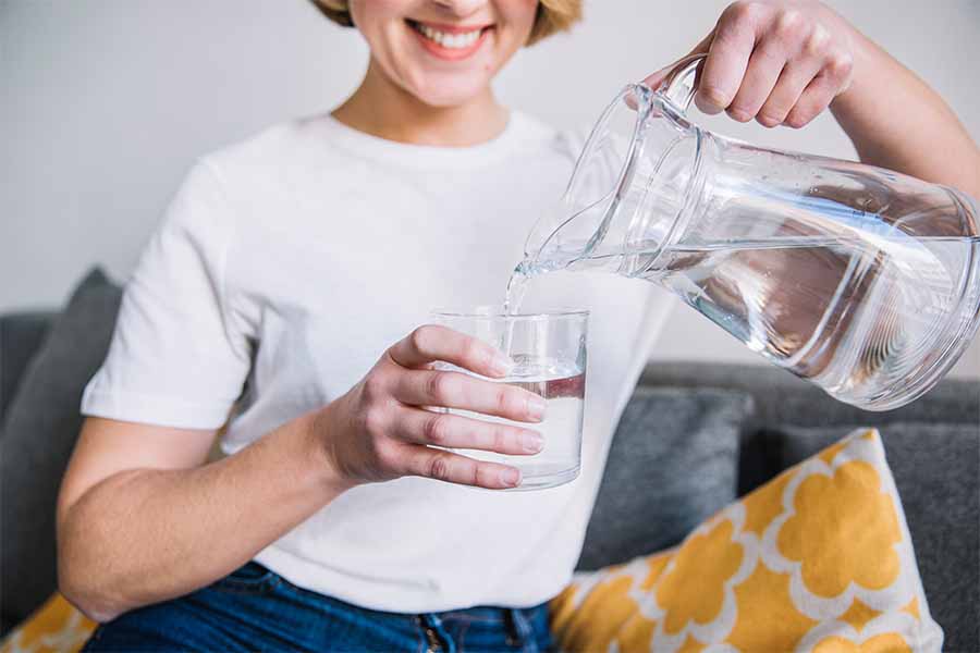 Mujer sirviéndose agua