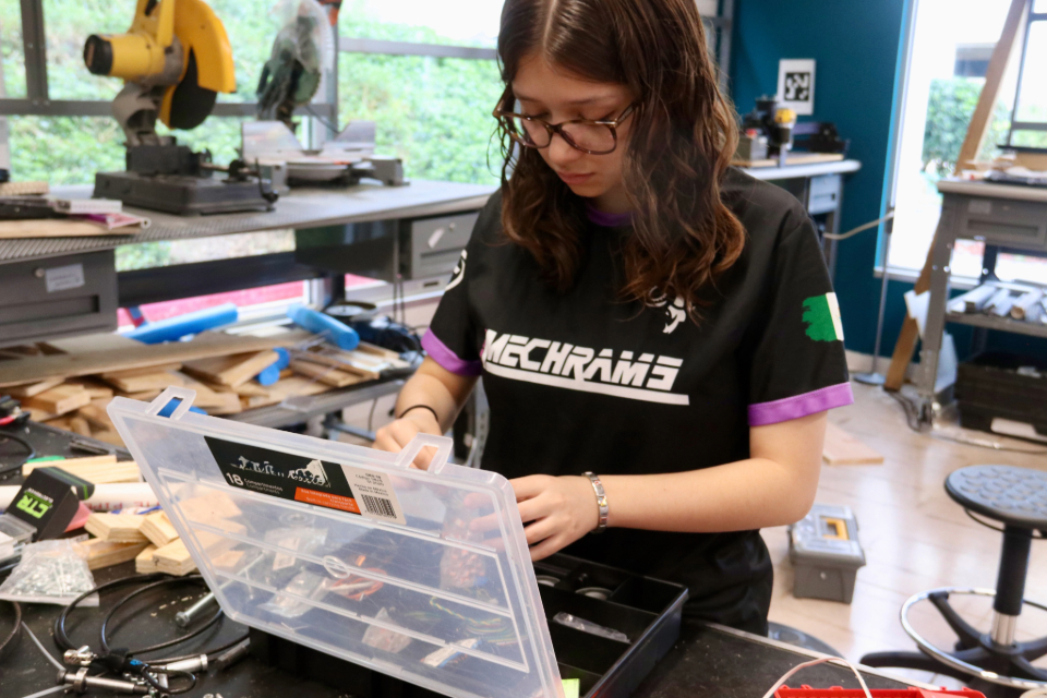 Alexandra Viezcas del equipo MechRams de PrepaTec del campus Chihuahua trabaja en el taller con maquinaria alrededor..