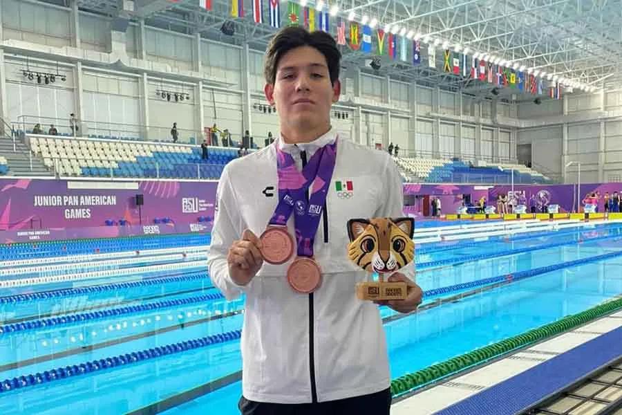 Deportista ense&ntilde;ando dos medallas y un trofeo de nataci&oacute;n. 