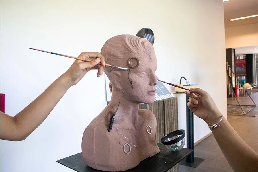 Alumnas pintando escultura que viajar&aacute; al festival de m&uacute;sica en Morelia