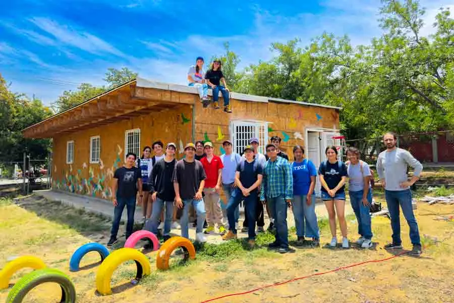 Alumnos participantes en la construcci&oacute;n del aula posan frente al sal&oacute;n.