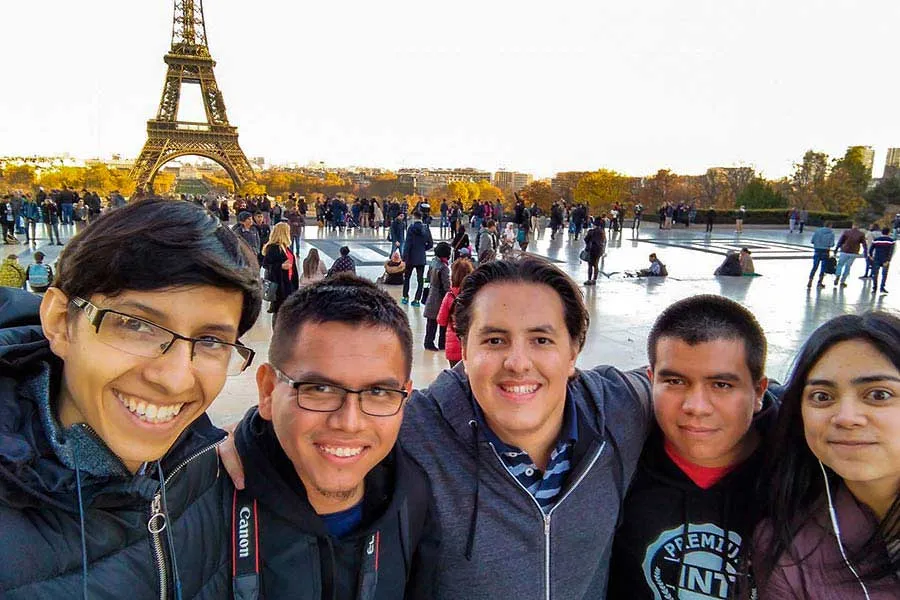Azael junto a sus amigos frente a la Torre Eiffel