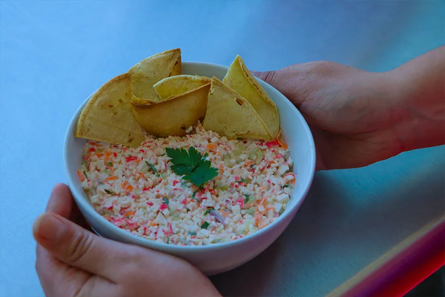 Ceviche de surimi servido con tortillas fritas en forma de totopos.