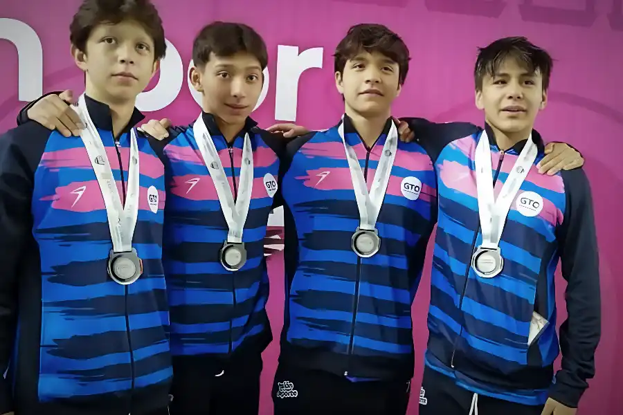 Diego Lizardi, Omar Ruelas, Isaac Vite y Mat&iacute;as Castillo, medallistas de plata en la prueba de relevos 4x100 en el Grand Prix, posan juntos con sus medallas sobre un fondo rosa.
