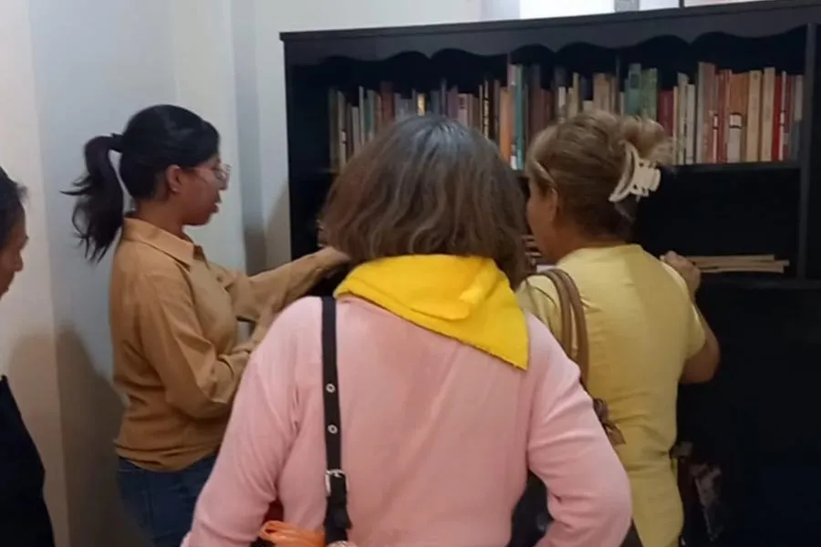 Viridiana explica a 3 adultos mayores sobre la biblioteca, en el centro gerontol&oacute;gico de Guanajuato.