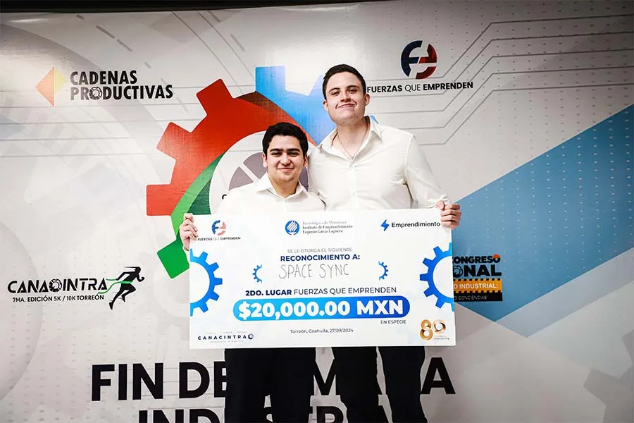 2 estudiantes del Tec de Monterrey posan con un cheque al ser ganadores de un concurso de emprendimientos organizado por CANACINTRA Torre&oacute;n