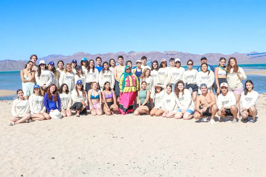 Foto grupal de j&oacute;venes del Tec con representante de la comunidad Comca'ac en la playa.