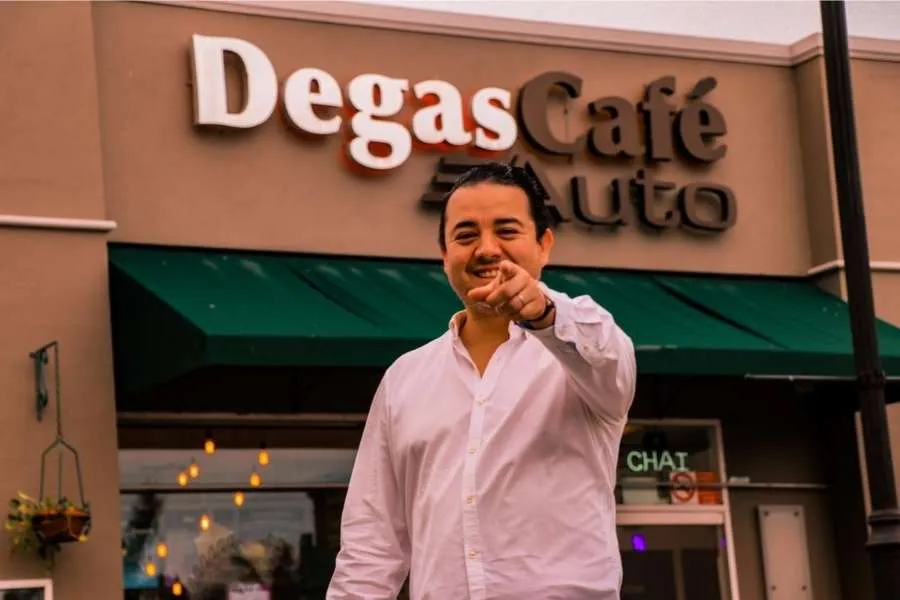 Gabriel frente a la fachada de una sucursal de Degas Caf&eacute;.