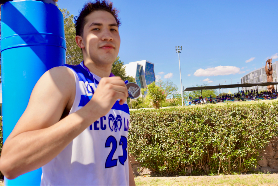 Juan Garc&iacute;a, jugador de la selecci&oacute;n varonil de basquetbol del Tec campus Laguna celebra su t&iacute;tulo mostrando su medalla.