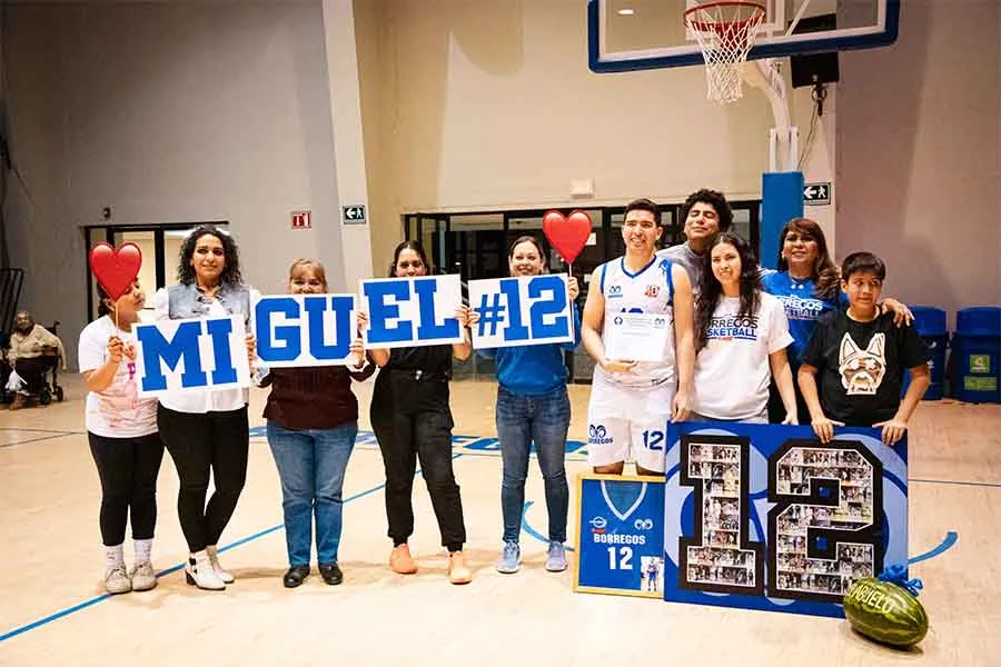 Miguel, egresado del Tec de Monterrey campus Laguna, posa con su familia para una fotograf&iacute;a en la duela de la arena de b&aacute;squetbol de Borregos Laguna