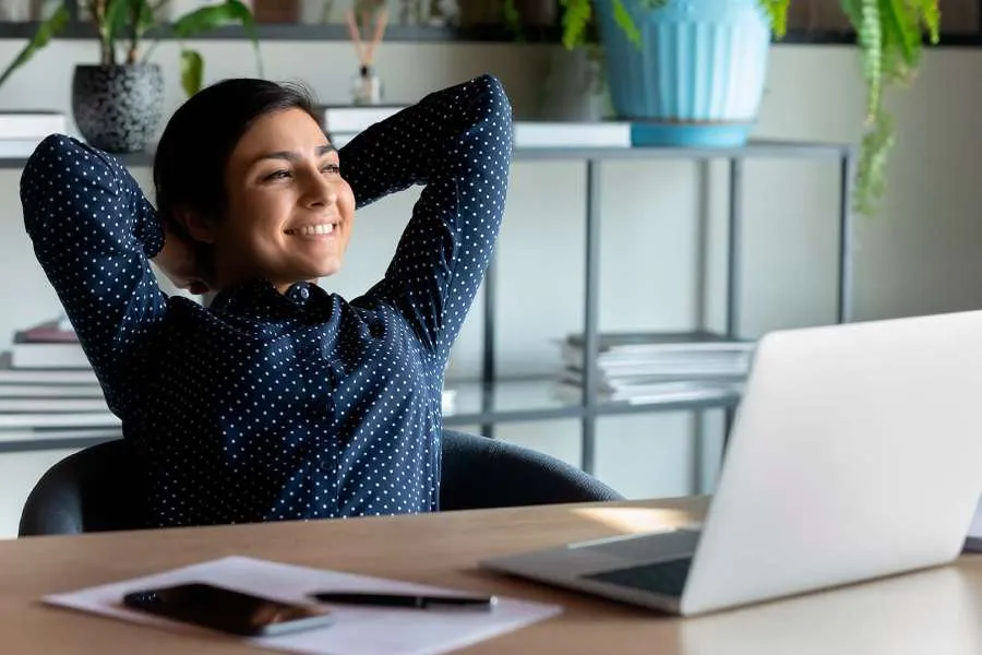 Empleada sonr&iacute;endo en su escritorio de trabajo