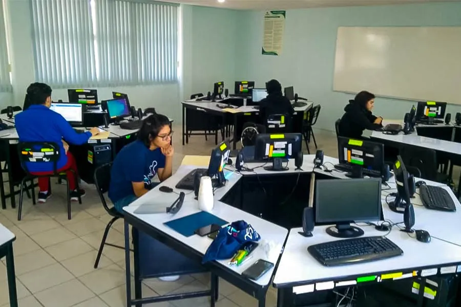 delegaci&oacute;n del estado separandos por mesas redondas para trabajar en computadoras 