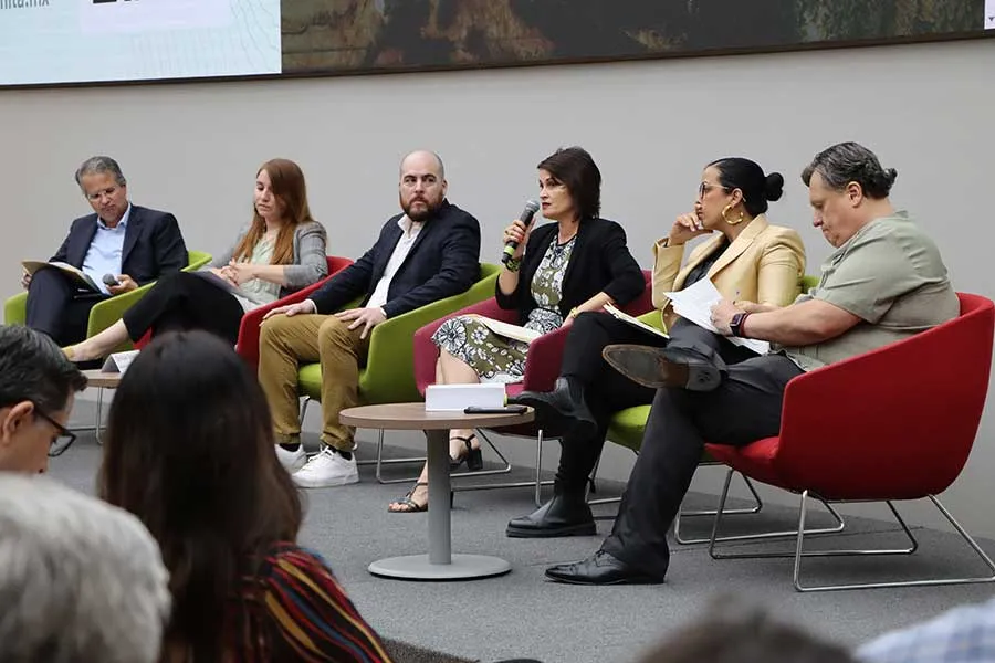 Personas colaborando en panel de discusi&oacute;n.