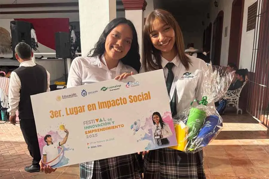Brenda y su compa&ntilde;era de proyecto recibiendo reconocimiento de Impacto Social