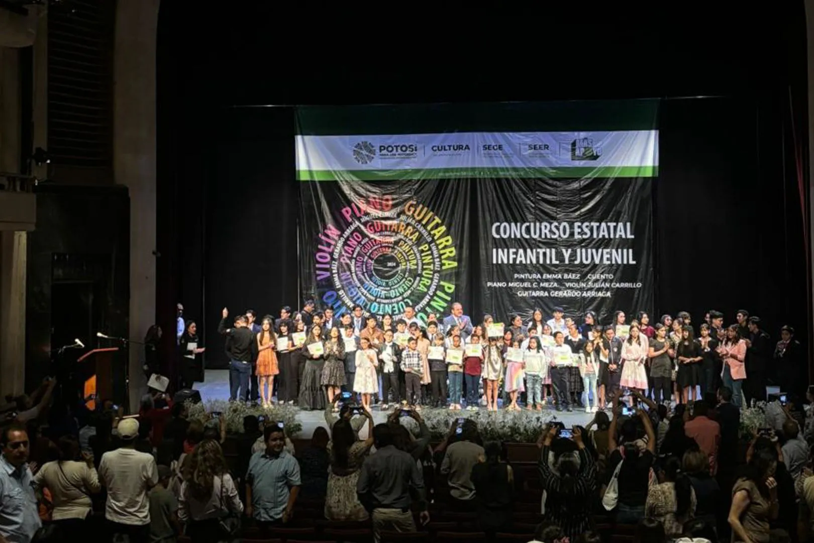 J&oacute;venes reconocidos en la competencia, est&aacute;n parados sobre un escenario
