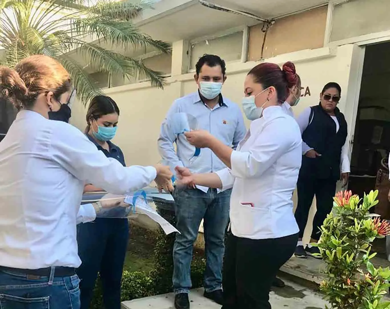 doctor abre paquete de proyecto nabawa de egresadis del Tec con caretas m&eacute;dicas para combatir covid19.