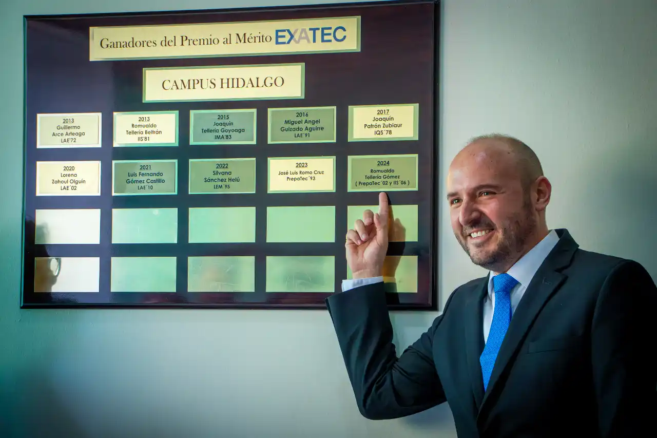 Ingeniero Romualdo Teller&iacute;a posando frente a placa de M&eacute;rito EXATEC