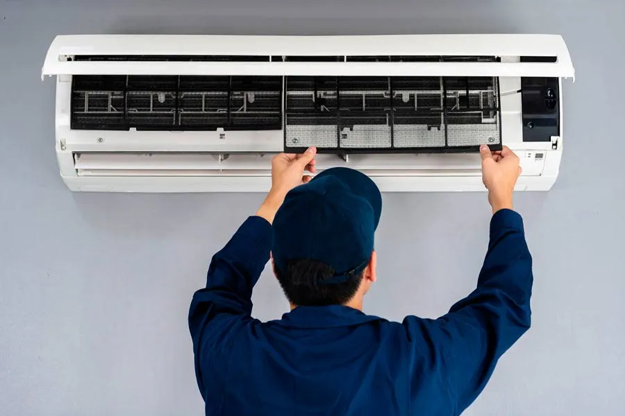 Se&ntilde;or revisando el aire acondicionado