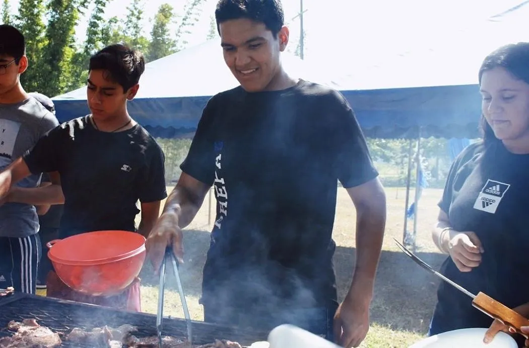 Sergio S&aacute;nchez asando carne junto con compa&ntilde;eros