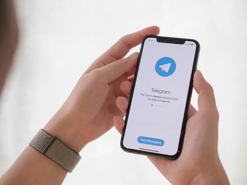 Mano sosteniendo tel&eacute;fono con Telegram