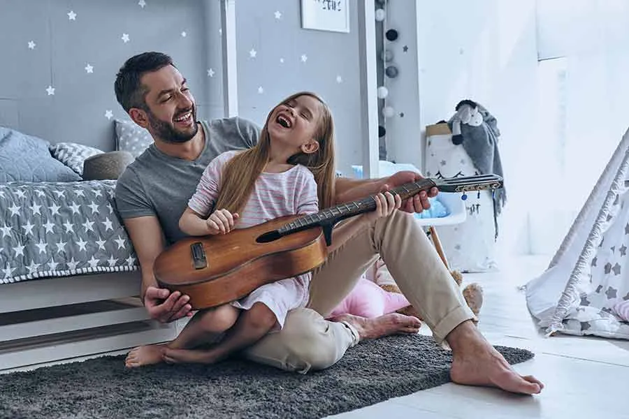 Pap&aacute; ense&ntilde;ando a su hija a tocar la guitarra