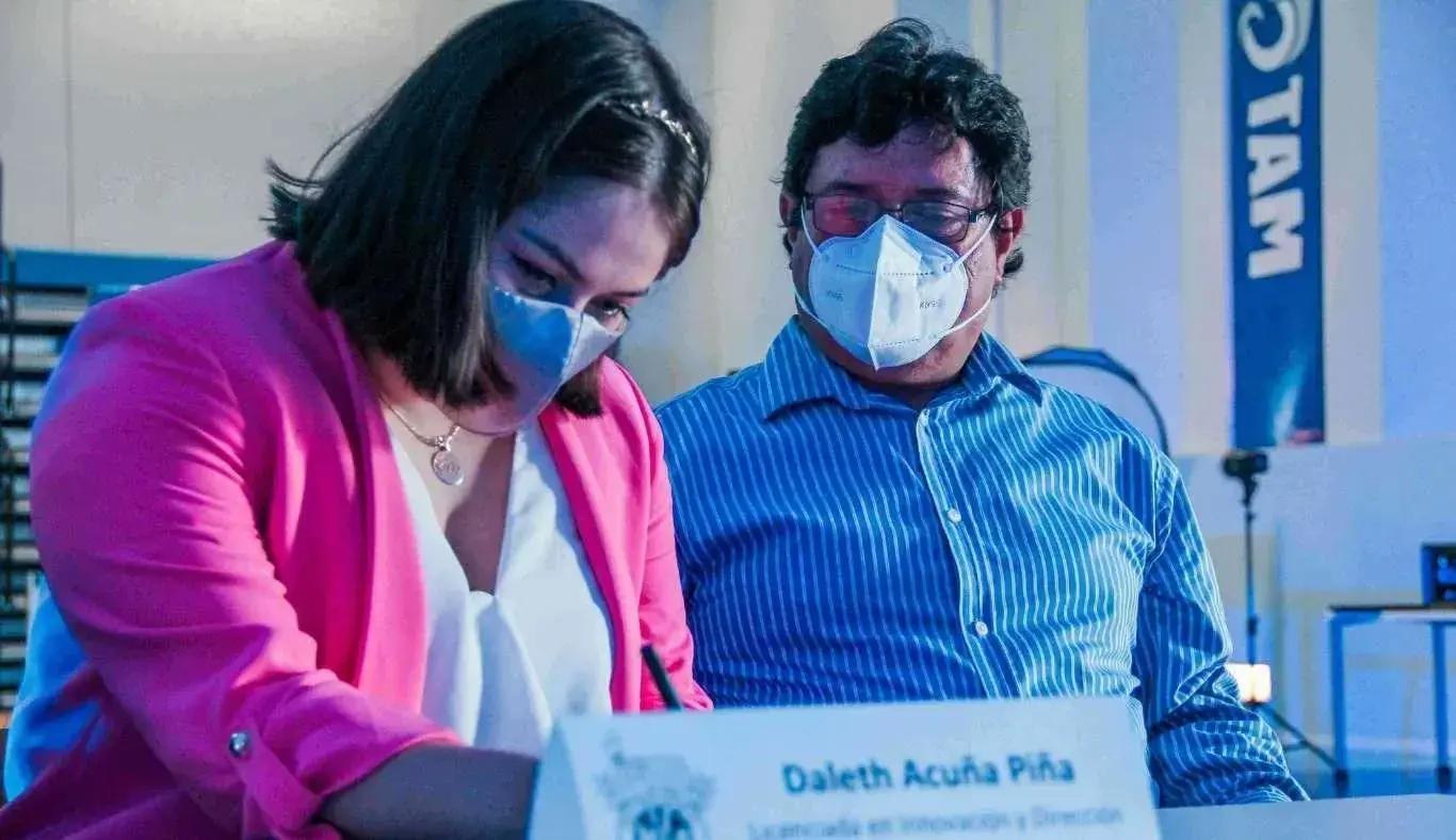 Padre acompañando a alumna a firmar su título profesional.