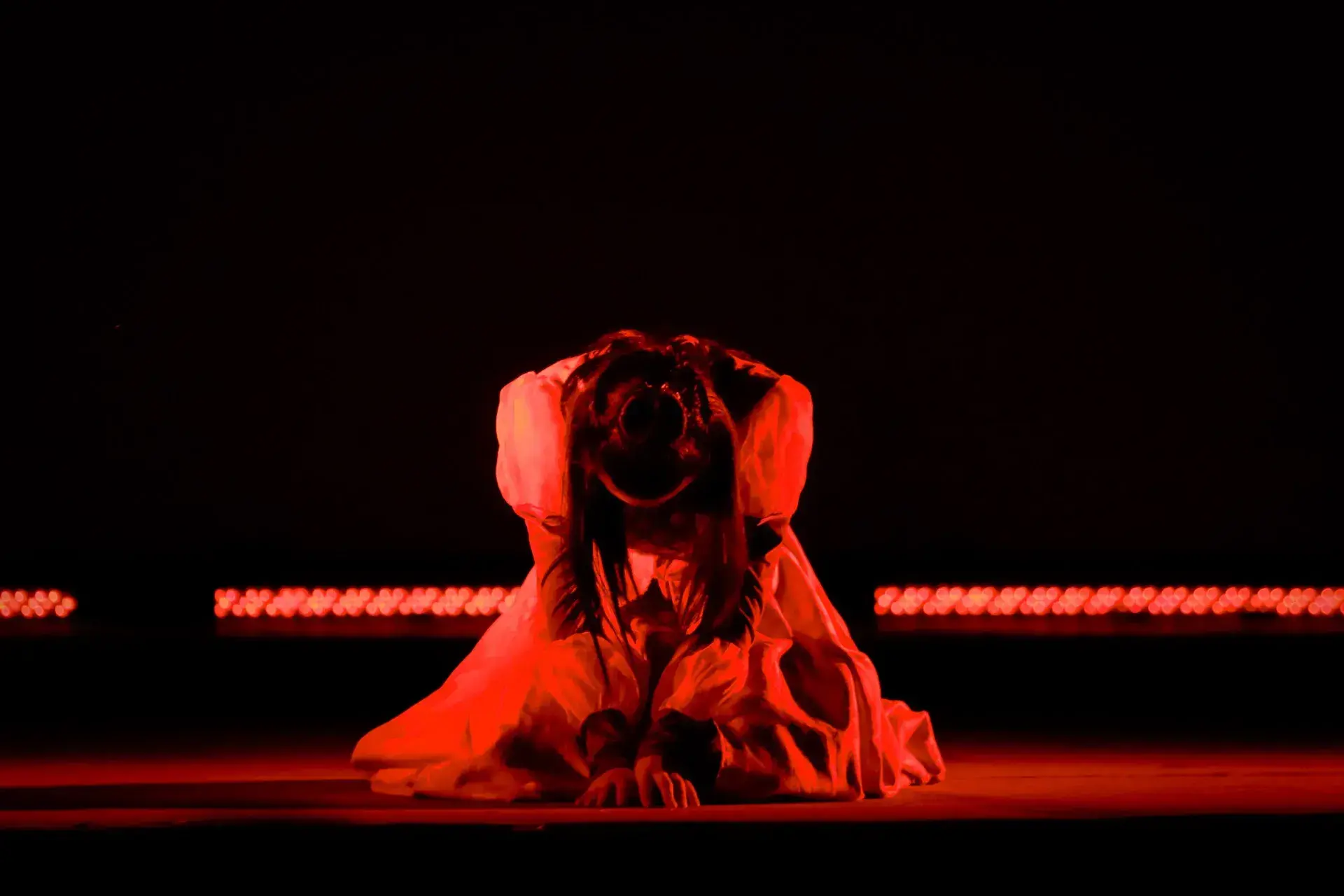 Actriz hincada en el piso con luz roja