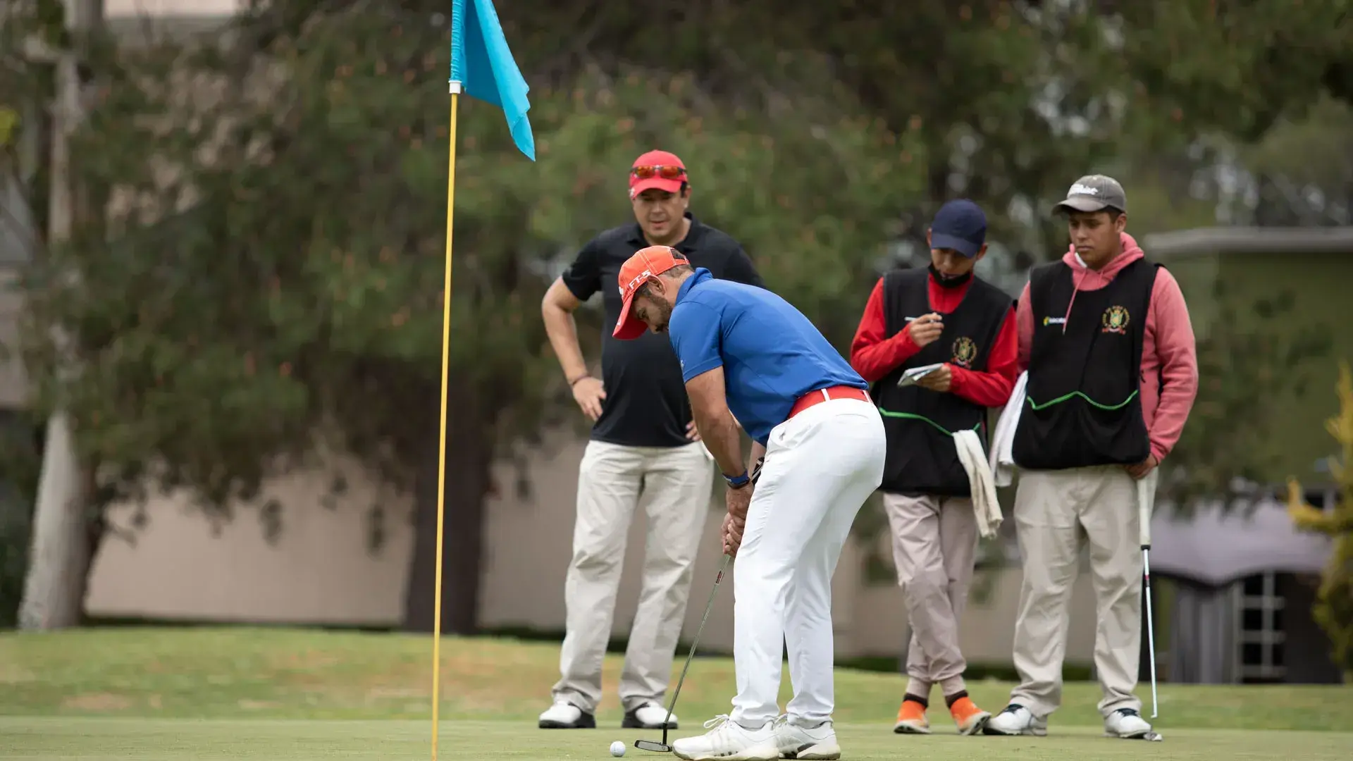 Grupo de jugadores viendo a golfista intentar el putt