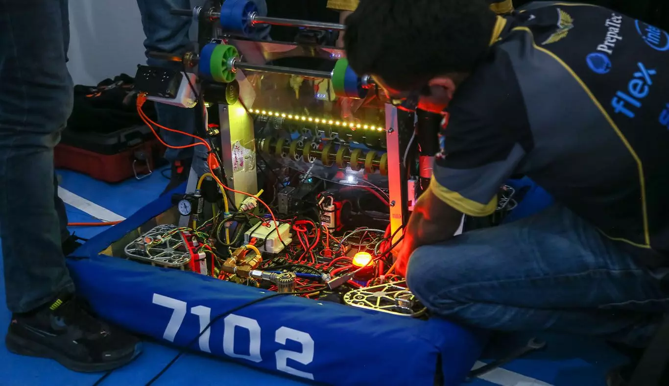 Jovnenes realizando reparaciones a su robot