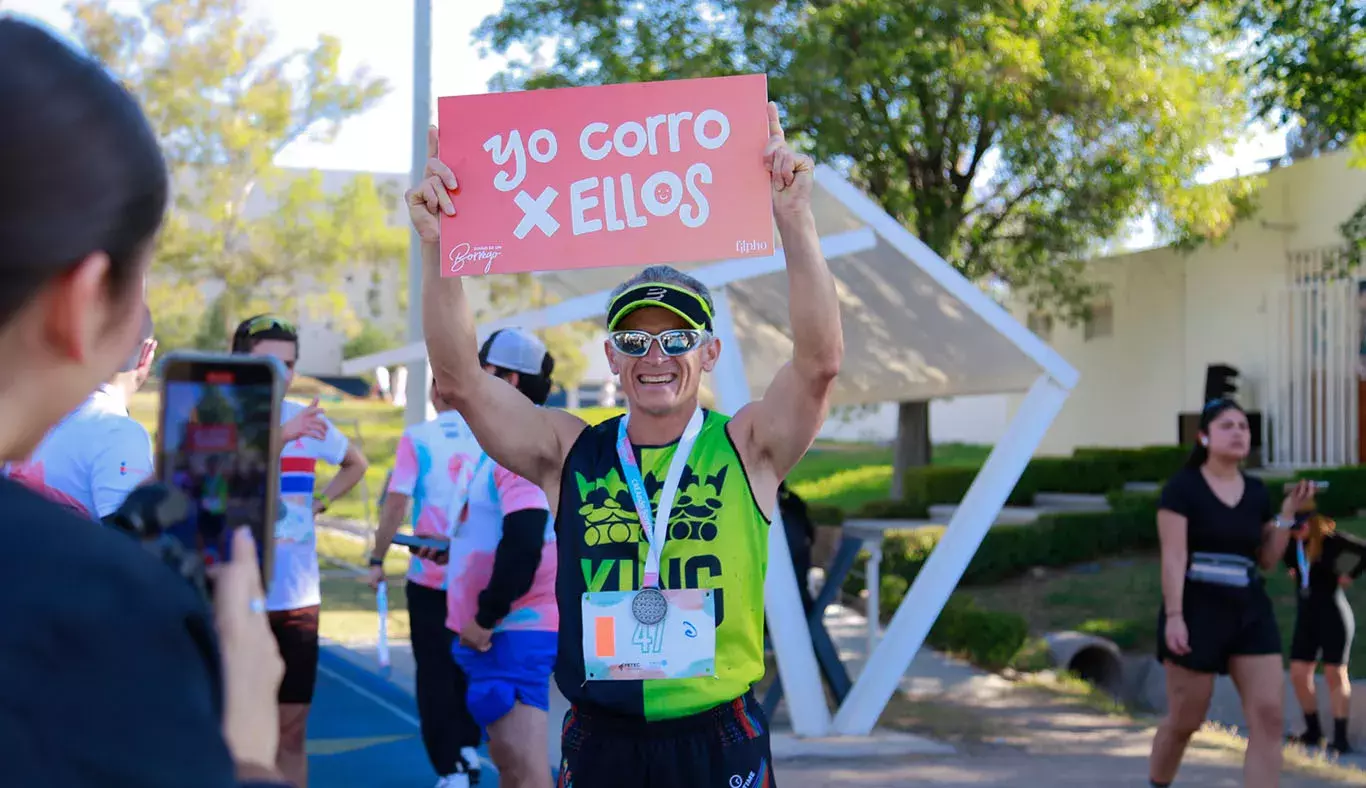 Persona sosteniendo un letrero de la carrera