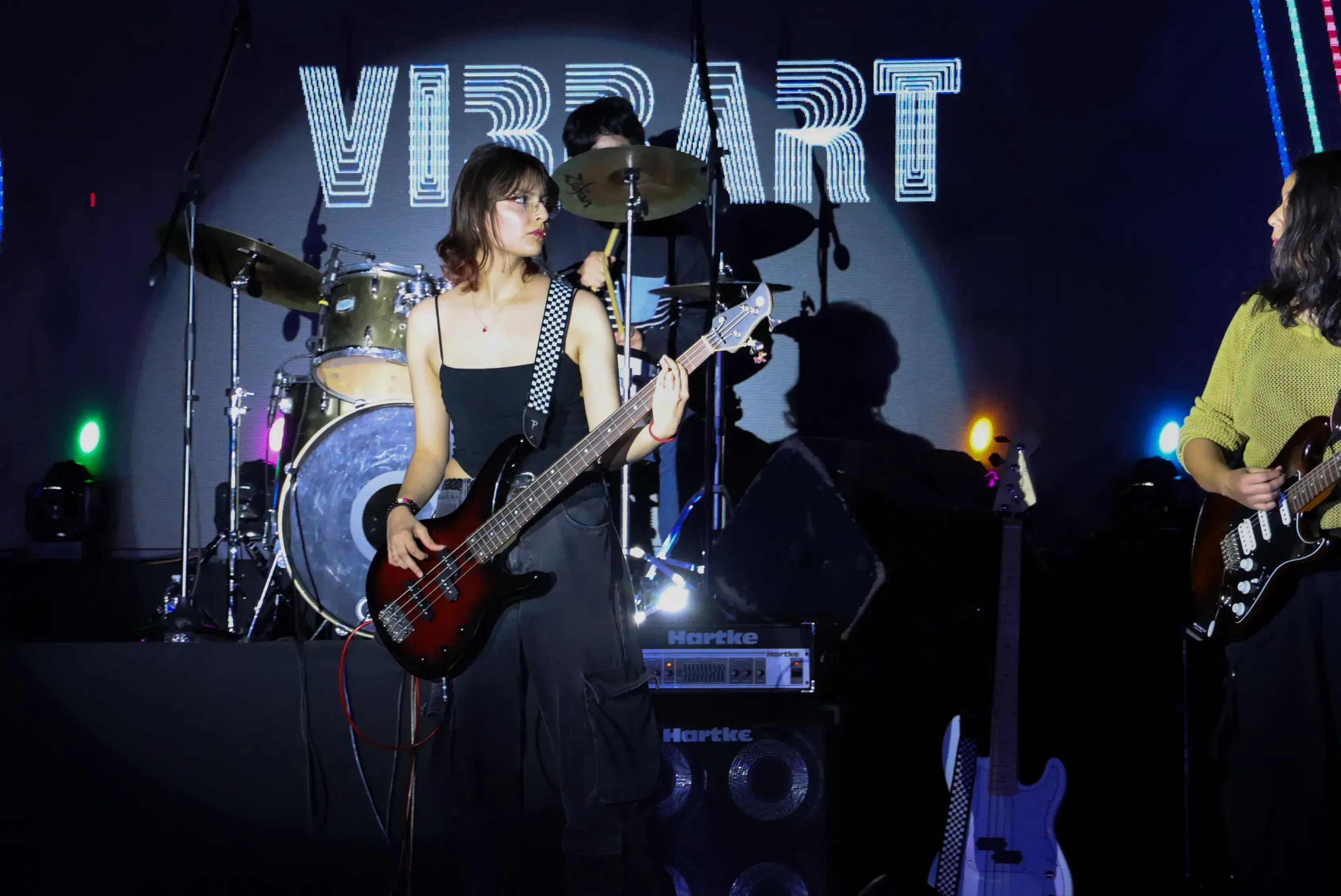 alumna tocando el bajo junto a su banda 