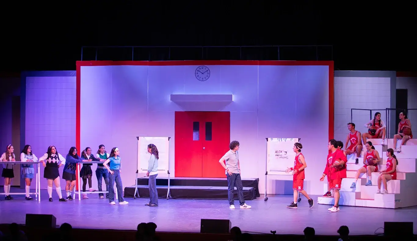 Escena del musical High School Musical: On Stage donde los personajes se preparan simultáneamente para el concurso de ciencias y el campeonato de baloncesto, con ambos grupos distribuidos a los extremos del escenario.