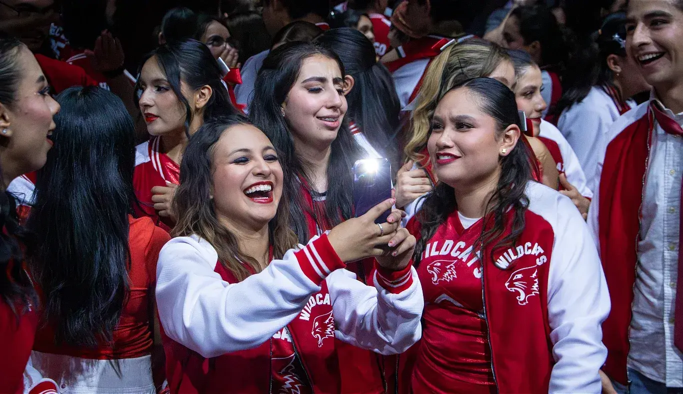 Integrantes del elenco de High School Musical: On Stage se toman una selfie entre risas y abrazos tras finalizar la obra, vistiendo chamarras rojas de los Wildcats en el campus Hidalgo.