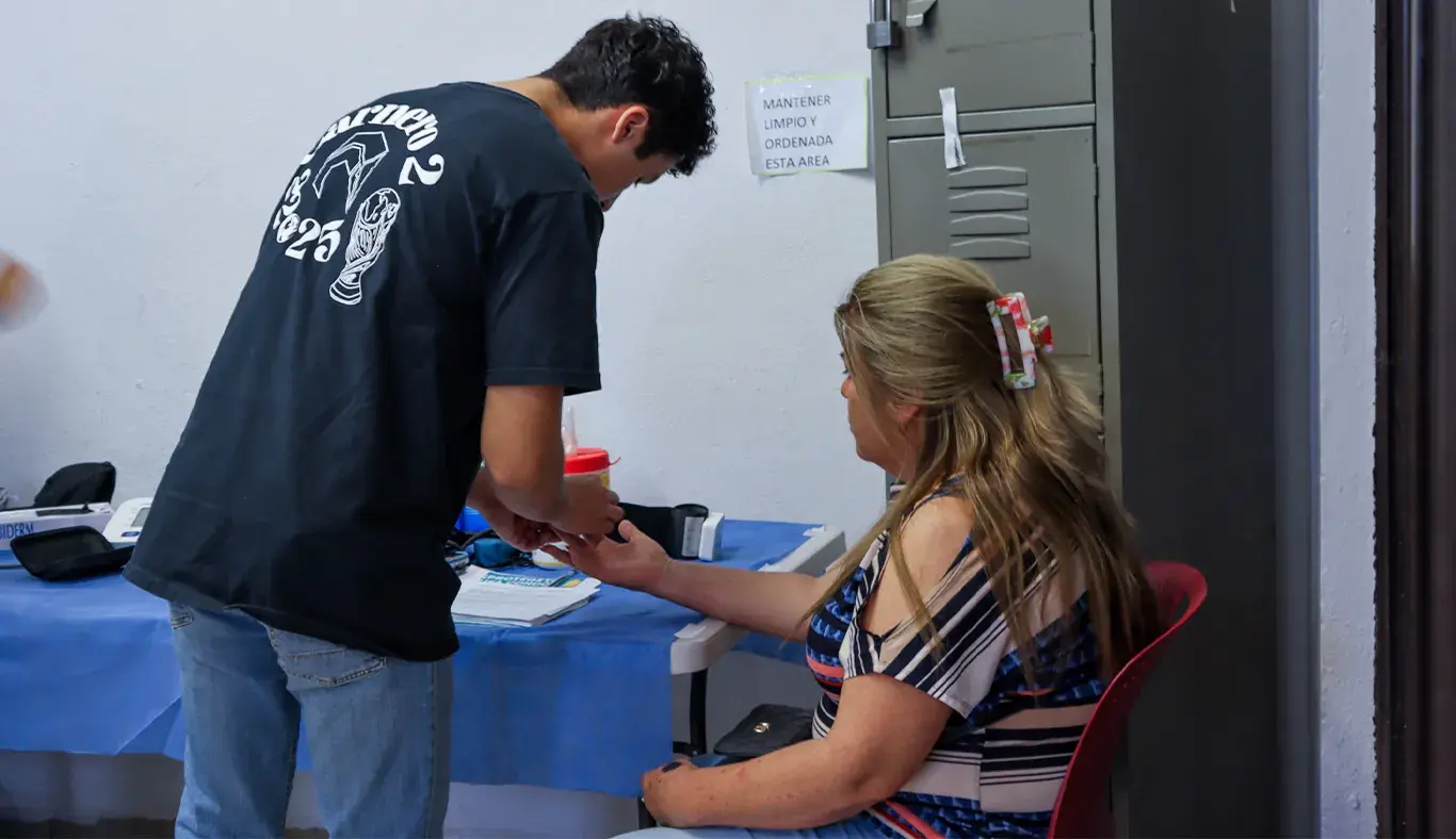 Voluntario tomando la presión arterial de una mujer. 