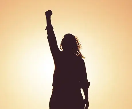 Sombra de mujer alzando la mano contra la violencia de género