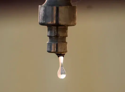 Gota de agua cayendo de una llave