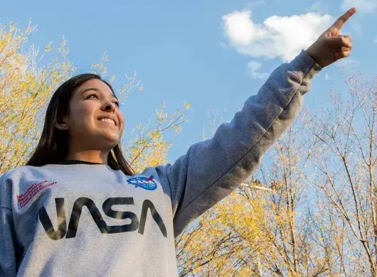 Carolina señalando el cielo con una sudadera de la nasa