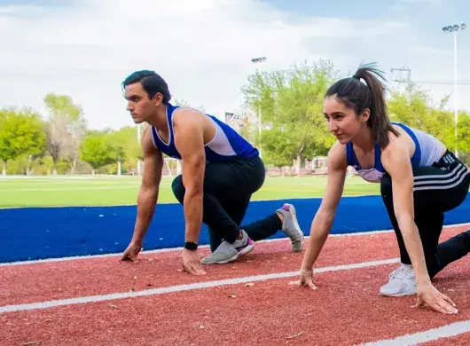 Sofia y Carlos en posición de marcas en la pista de atletismo