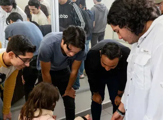 Estudiantes entregando silla a niña del CREE