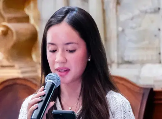Regina Gutiérrez recitando poema en recinto