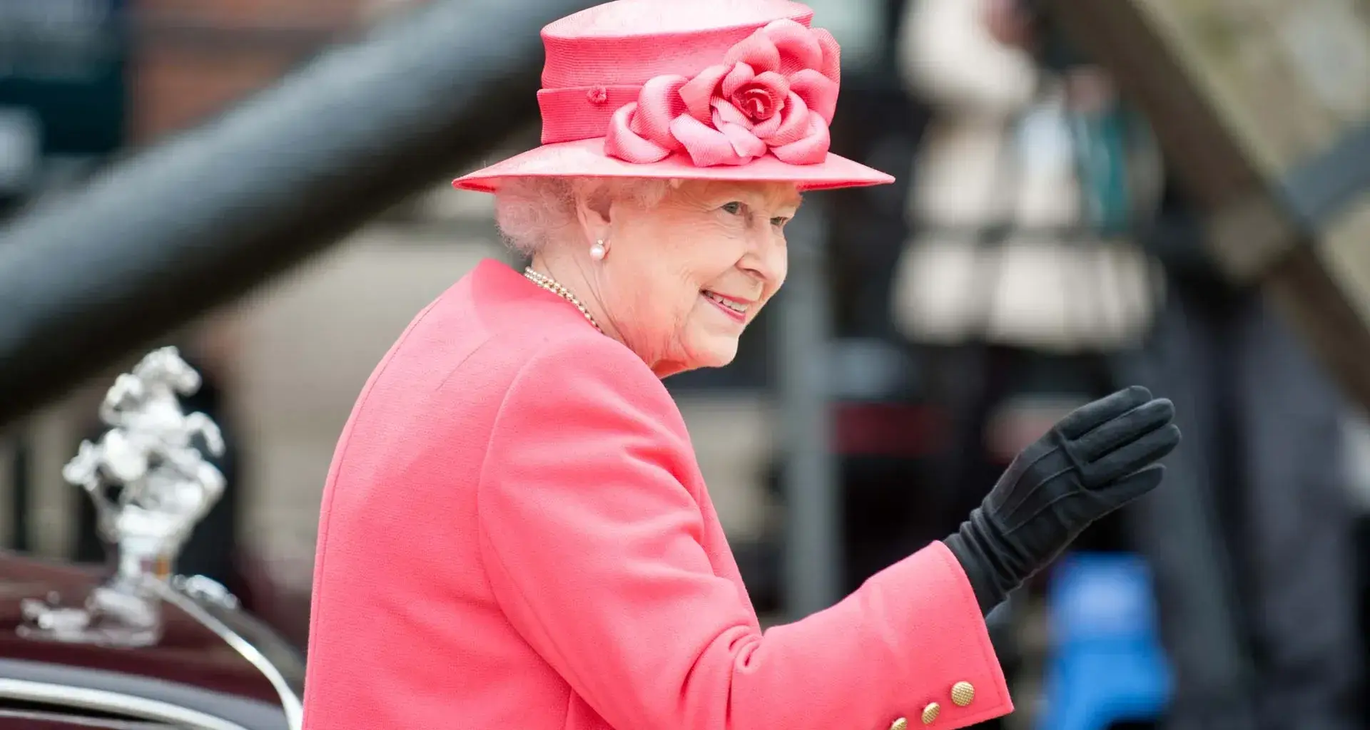 La reina Isabel saluda y sonríe en el Palacio de Buckinham