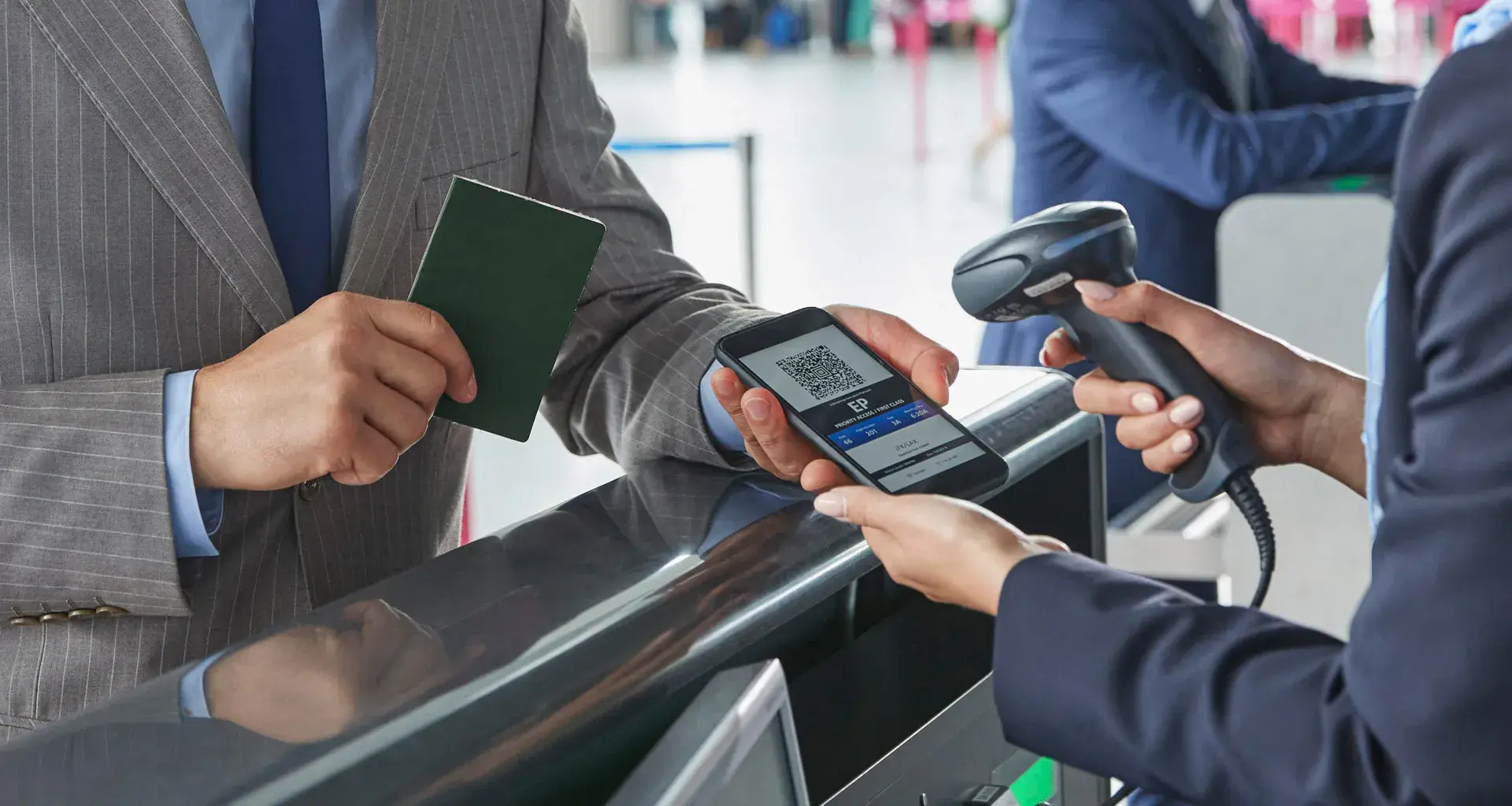 Representante de atención al cliente escaneando el código QR del pase de abordar en un teléfono inteligente en el mostrador de check-in del aeropuerto.