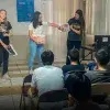 Estudiantes enseñando ciencia frente a un grupo. 